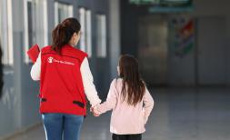 Save the Children staff with a girl in a school used as a shelter
