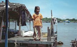  Mara, 9, standing for a portrait on a fishing farm platform on Tonle Sap lake, Kompong Thom province, Cambodia.