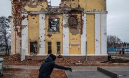 A schoolboy plays tennis near the building of Gymnasium No. 134 in Kharkiv, which was completely destroyed at the beginning 